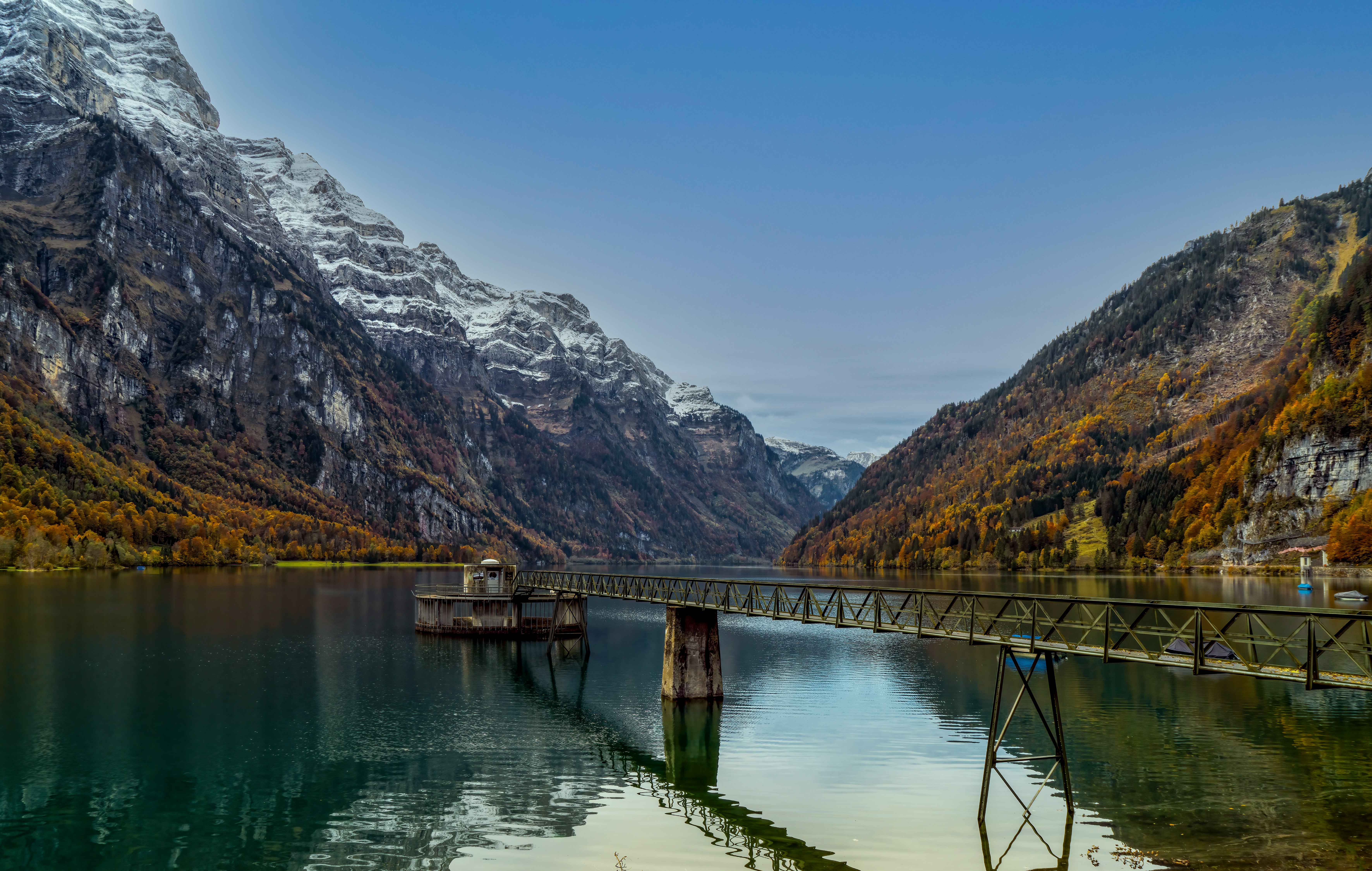 brown wooden dock on lake near mountain during daytime